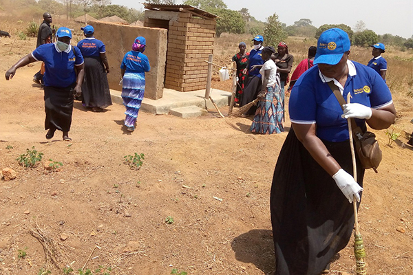Members of the Rotary Club of Yumbe, Uganda, participate in a community clean-up project in Achiba village.