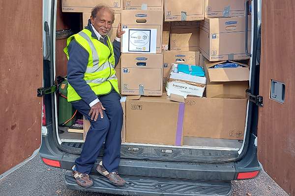 Dr. Philips in yellow vest in back of van loaded with supplies