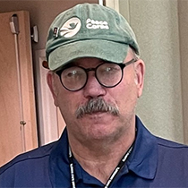 Walsh wearing olive green cap and glasses