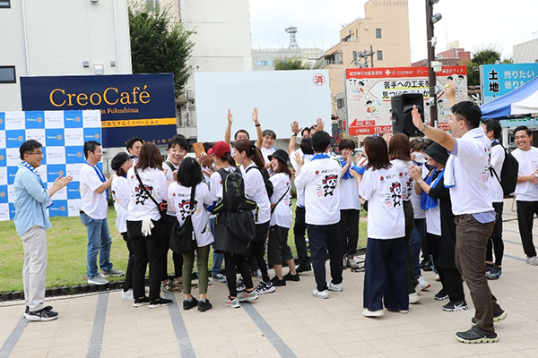 A group of young people with their arms in the air celebrating at a park in Japan