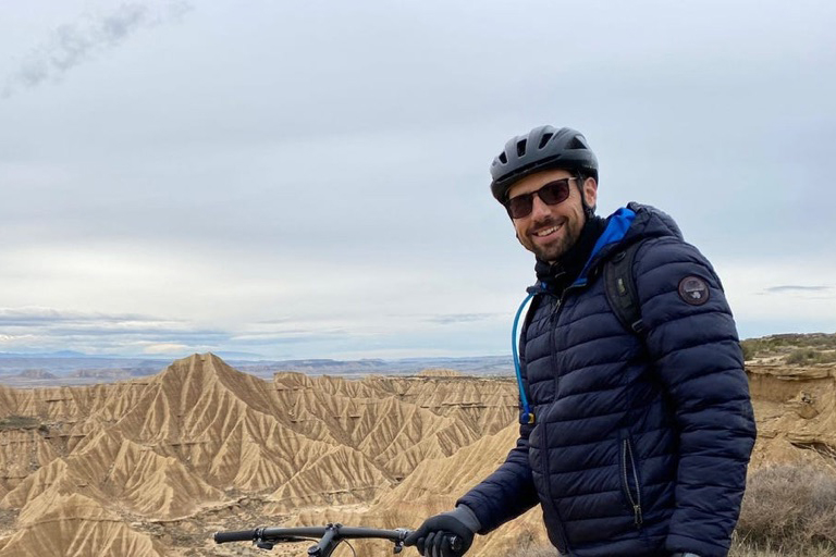 Benjamin Parent by his cycle in front of mountains
