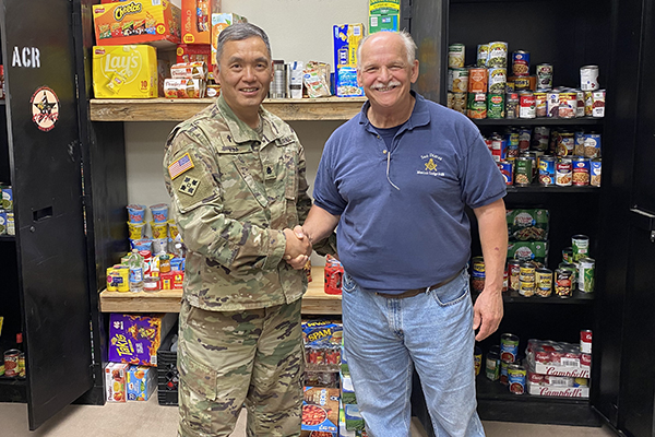 The blog author shakes hands with a Lt. Colonel in a food pantry.